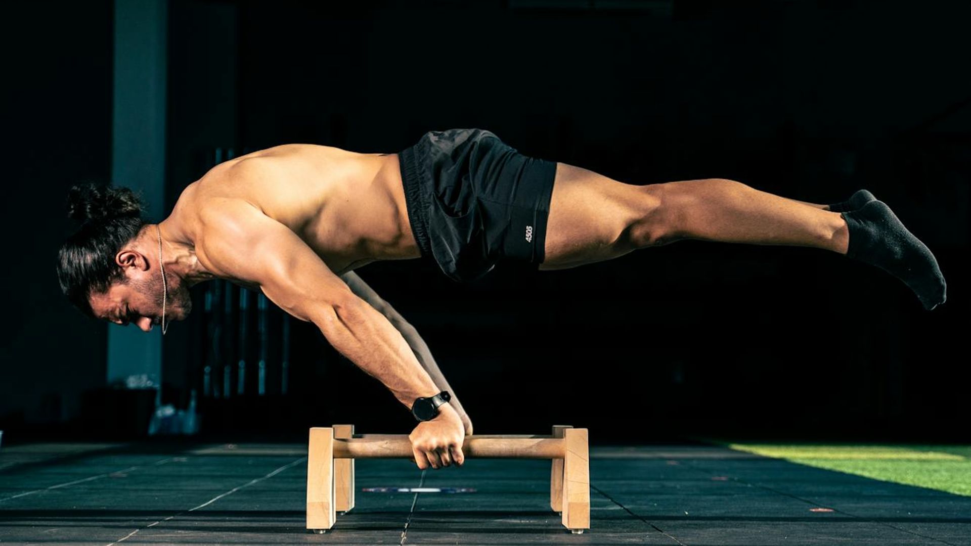 Man performing a controlled bodyweight exercise in a spacious, minimalist room.